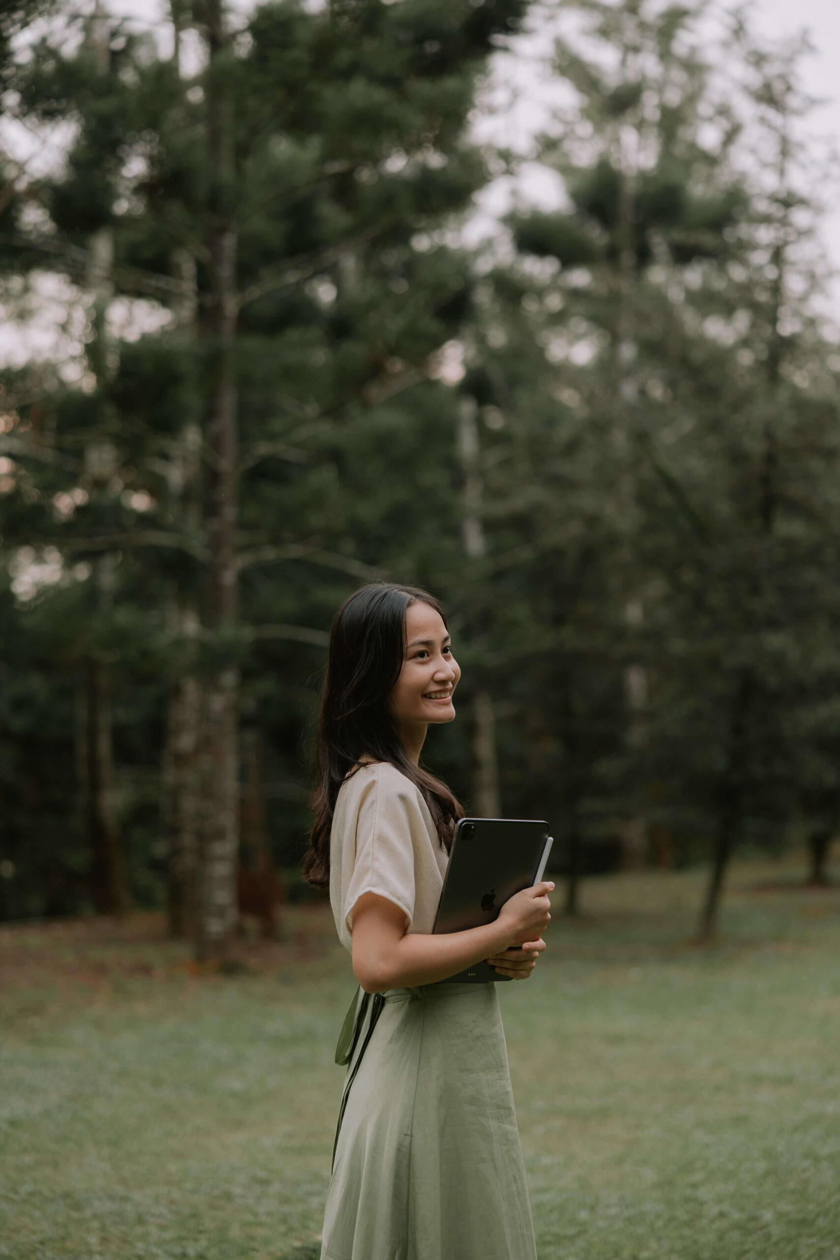 A brand designer holding an iPad outdoors, expressing a calm and aligned approach to creating intentional brand identities.