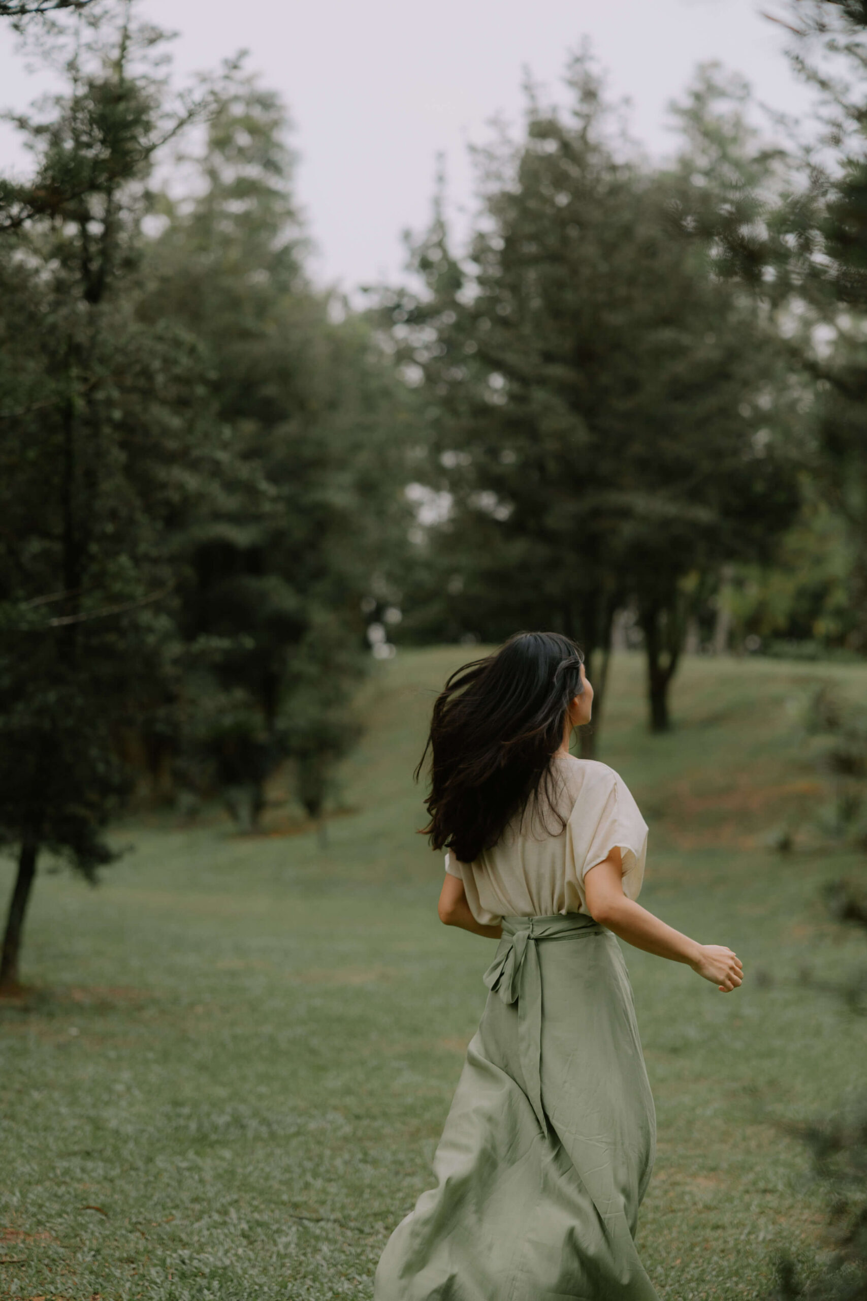 A creative entrepreneur walking gently through nature, symbolizing a softer, more intentional way to work and create.